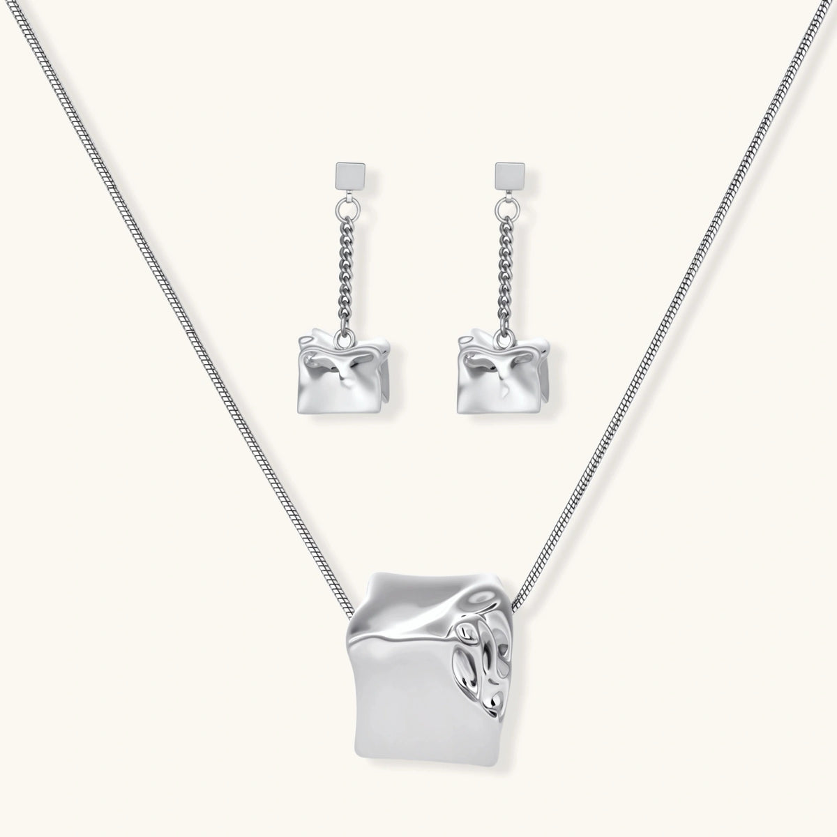 Geometric jewelry set with textured cube pendants on chains, featuring eco-zinc alloy in silver and gold finishes.
