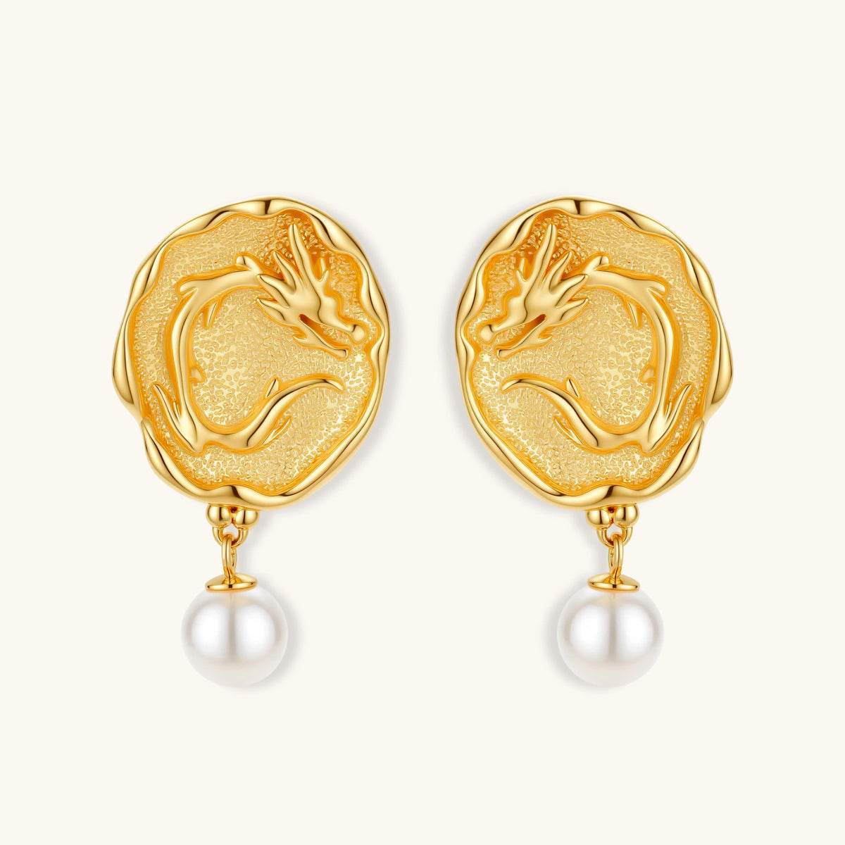 Ornate gold-plated dragon medallion earrings with white shell pearl drops on beige background, featuring detailed Chinese motifs.