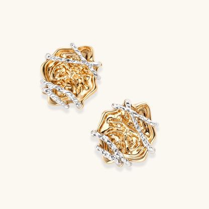 Sculptural rose-shaped stud earrings in gold with silver wire details and S925 posts on cream background.